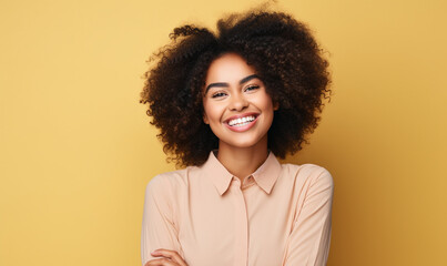 Obraz na płótnie Canvas Portrait of beautiful young Beautiful African American girl with an afro hairstyle laughing. Isolated on yellow background