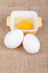 raw white eggs and yolk in small yellow bowl