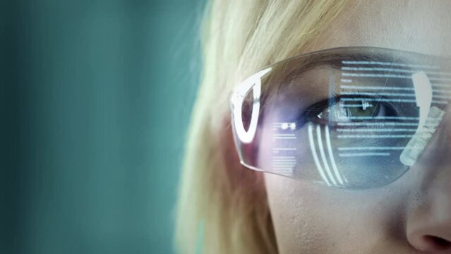 Woman wearing futuristic and technologically advanced glasses. Reading holographic text displayed on glass.