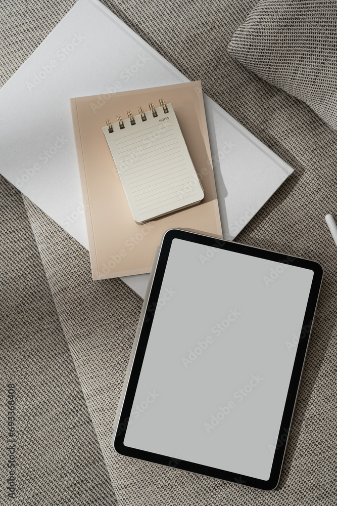 Wall mural tablet pad with blank copy space screen, notebook, documents on sofa. minimal online branding concep