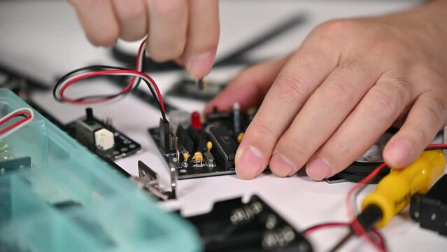 Close-up of hands assembling robotics educational toy. STEM education concept