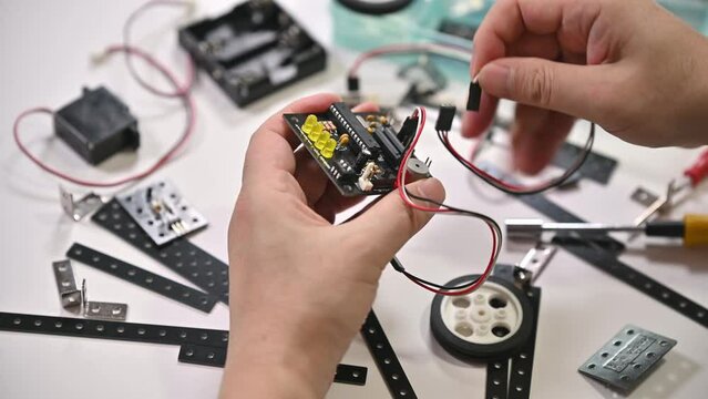 Close-up of hands assembling robotics educational toy. STEM education concept