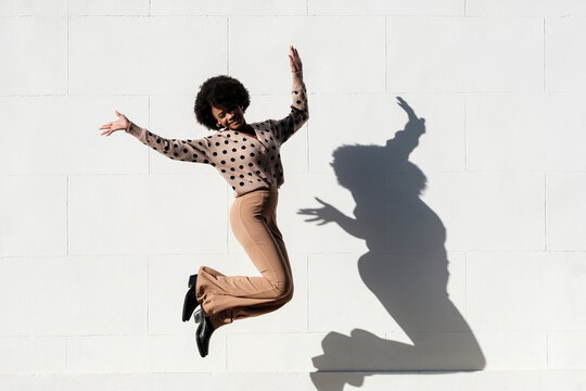 Carefree young happy woman jumping in the street.