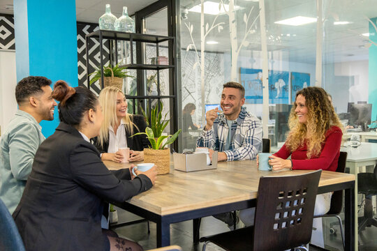 Office colleagues gather for coffee in a casual meeting