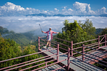 Asian traveler woman happy with the beautiful sea mist in the morning of mountain peaks the Thai...