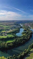 Die Flussschleife bei Homburg am Main windet sich durch das Tal und ist von Bäumen und Weinbergen...
