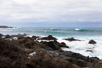 Panoramic view of Playa El Golfo volcanic beach and rocky coast on a windy day. Seen from the Charco de los Clicos viewpoint. Lanzarote, Canary Islands, Spain