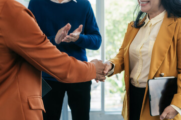 Business men and women shake hands confidently professional investor working with new startup project at an office meeting.