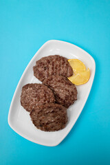 fried cutlet for burger with lemon. In a white plate