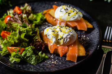 Toast with poached egg in a plate. Salad