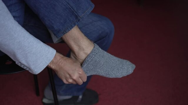 Man putting on socks at home