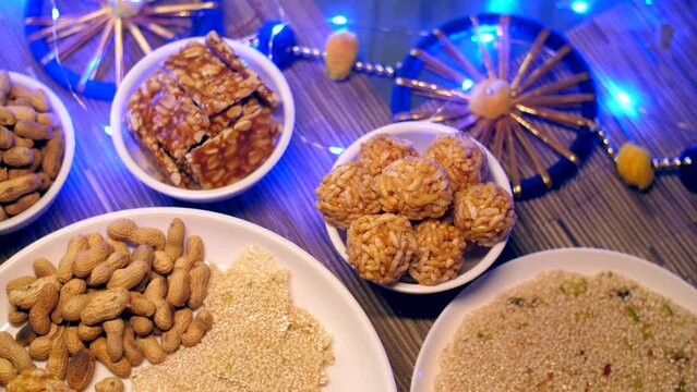 Top view shot of plate full of various sweets rotating on a turntable for Lohri celebration in India . Beautifully plated homemade sweets consumed during Lohri festival - winter season