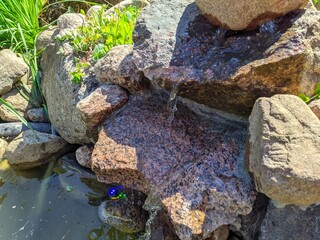 water flows through stones on a summer cottage during the day in the summer.