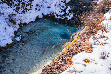 雪が残ったエメラルドグリーンの小大野川