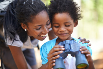 Happy, binocular or black family hiking in forest to relax or bond on holiday vacation together in nature. Child, sightseeing or African mom in woods or park to travel on outdoor adventure with smile - obrazy, fototapety, plakaty