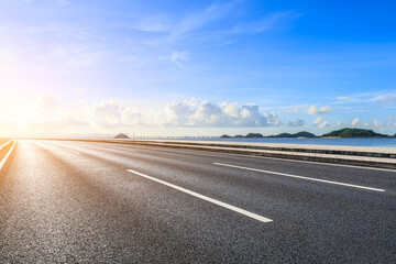 Asphalt highway road and beautiful coastline nature landscape at sunrise