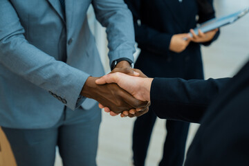 Closeup of business hands shaking between businessman and professional male leader while smart...