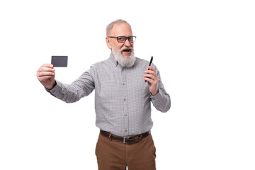 a handsome old man with a mustache and a beard in glasses is dressed in a shirt and trousers shows...