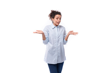 brunette curly young employee of a business company woman dressed in a light blue shirt on a white...