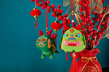 A New Year's toy in the shape of a green dragon hangs on a branch tree. Festive background. Chinese...