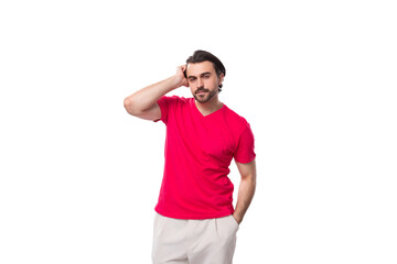 Fototapeta premium young brutal black-haired man dressed in a red corporate t-shirt on a white background