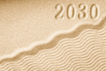 Imprints of numbers 2030 new year on a golden sand waves