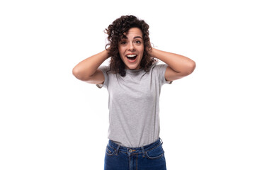 well-groomed european woman with natural black curly hair in a gray basic t-shirt on a white...