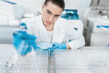 Young woman scientist working conducts research in modern bio laboratory. Female doctor laboratory...