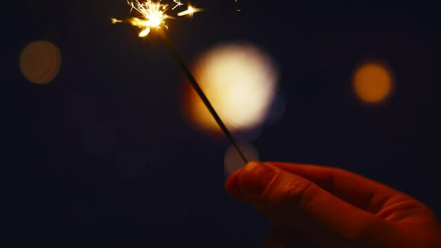 A sparkler and fireworks display in the background. Shot with RED helium camera in 8K.  