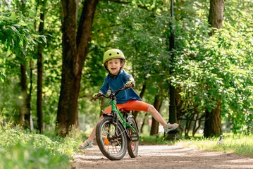 Foto op Canvas A child learning to ride a bicycle is unable to maintain balance and falls down. © alexei_tm
