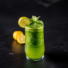 Mint lemonade in glass both on a black background 