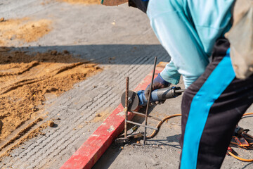 Worker cutting reinforcement with hand tools.