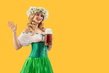 Midsummer woman waitress serving big beer mugs on yellow isolated background. Blonde girl with...