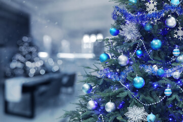 Christmas tree decorated with light blue and silver festive balls against blurred background, bokeh...