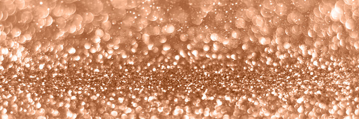 Peach fuzz sparkling glitter bokeh background banner, abstract panoramic defocused texture. Holiday lights header