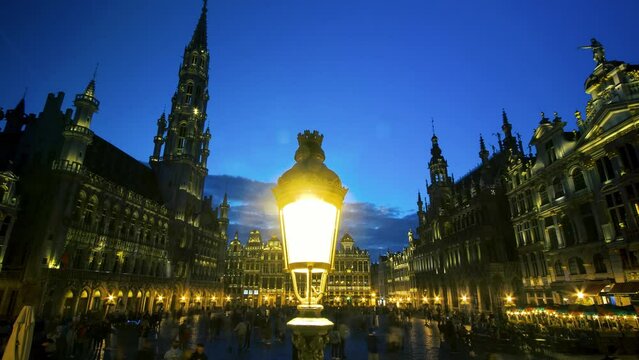 The Grand-Place or Grote Markt at night with tourists is the central square of the city of Brussels. It is surrounded by guild houses, the H&ocirc;tel de Ville and the Maison du Roi. UNESCO heritage
