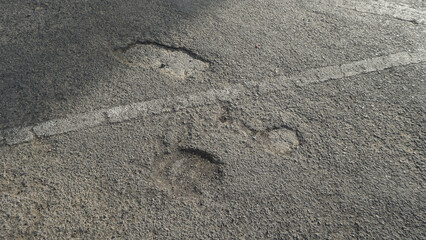 The road asphalt is destroyed with holes