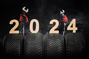 Car tires, winter wheels, new tyres in fog and hands of mechanic with wrench instruments, happy new...