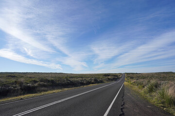 Beautiful landscape of the empty road in the meadow with blue sky background