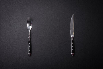 Kitchen knife and fork made of steel with copy space - obrazy, fototapety, plakaty
