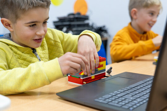 Excited children building a robot at school