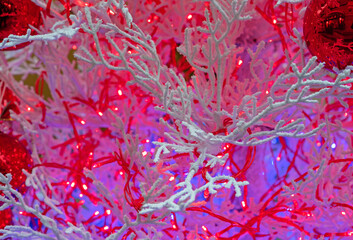 Christmas background with snow-covered branches and red garland.