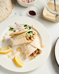 Beef and Lamb Lebanese style shawarma with onions, greens and vegetables such cucumber and tomato. all seasoned with tahini and garlic sauce and wrapped in pita or pita bread.