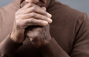 Fototapeta premium praying to god Caribbean man praying with black background with people stock photo