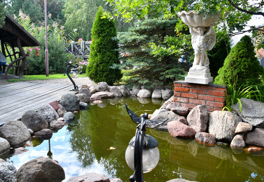 Little garden pond with miniature bronze sculptures