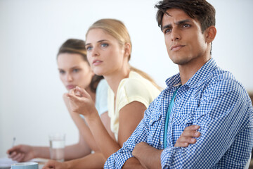 Serious, meeting and arms crossed with documents, teamwork and planning design strategy with workers. Man, women and tech for email, work or project for conversation, workplace and professional