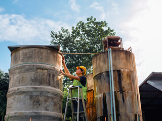 engineer controlling the quality of water Stand on the risky stairs at high places operating...