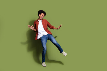 Full length photo of nice young male dancing boogie woogie wear trendy brown garment isolated on khaki color background