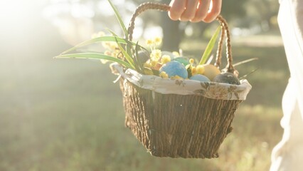 A Woman in White Strolls with a Basket of Easter Eggs in the Forest, Walking towards the Sunbeams. Cinematic Lighting in a Woodland Setting.
