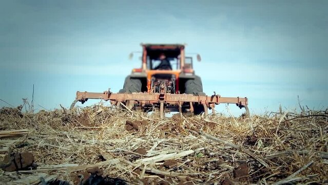 Tractor Plowing in the Field. Low Angle View. 